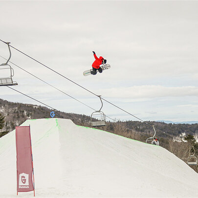 Snowboarder getting air off of a terrain park feature