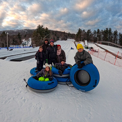 Smiling family poses in front of tubing park