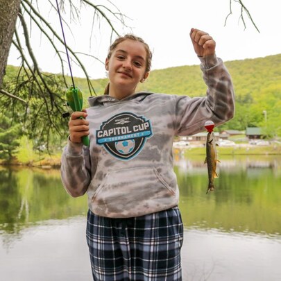 Girl at Fishing Derby showing the trout she caught