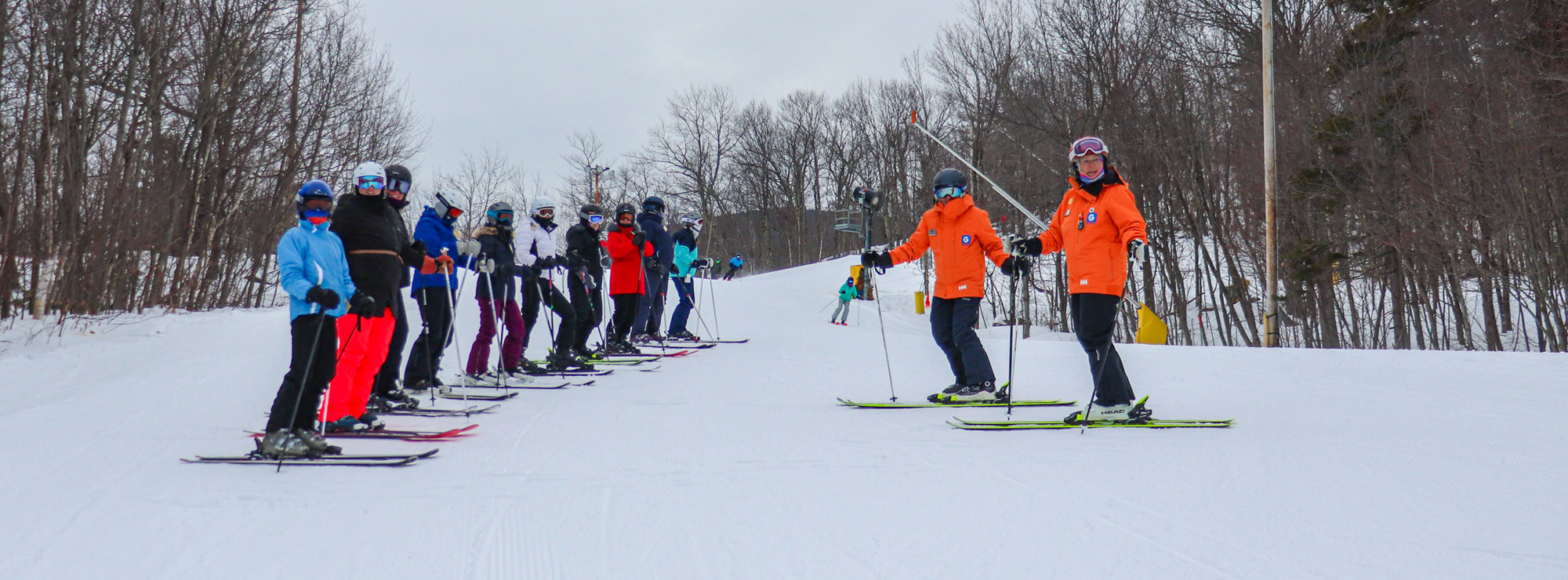 Two ski instructors talk to their class