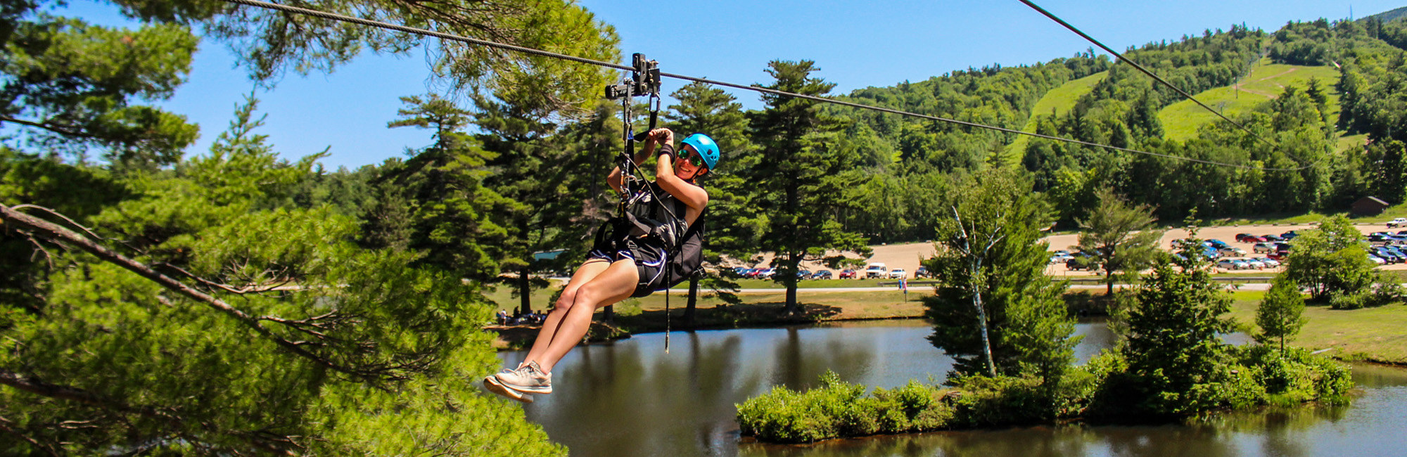 woman ziplining over the pond