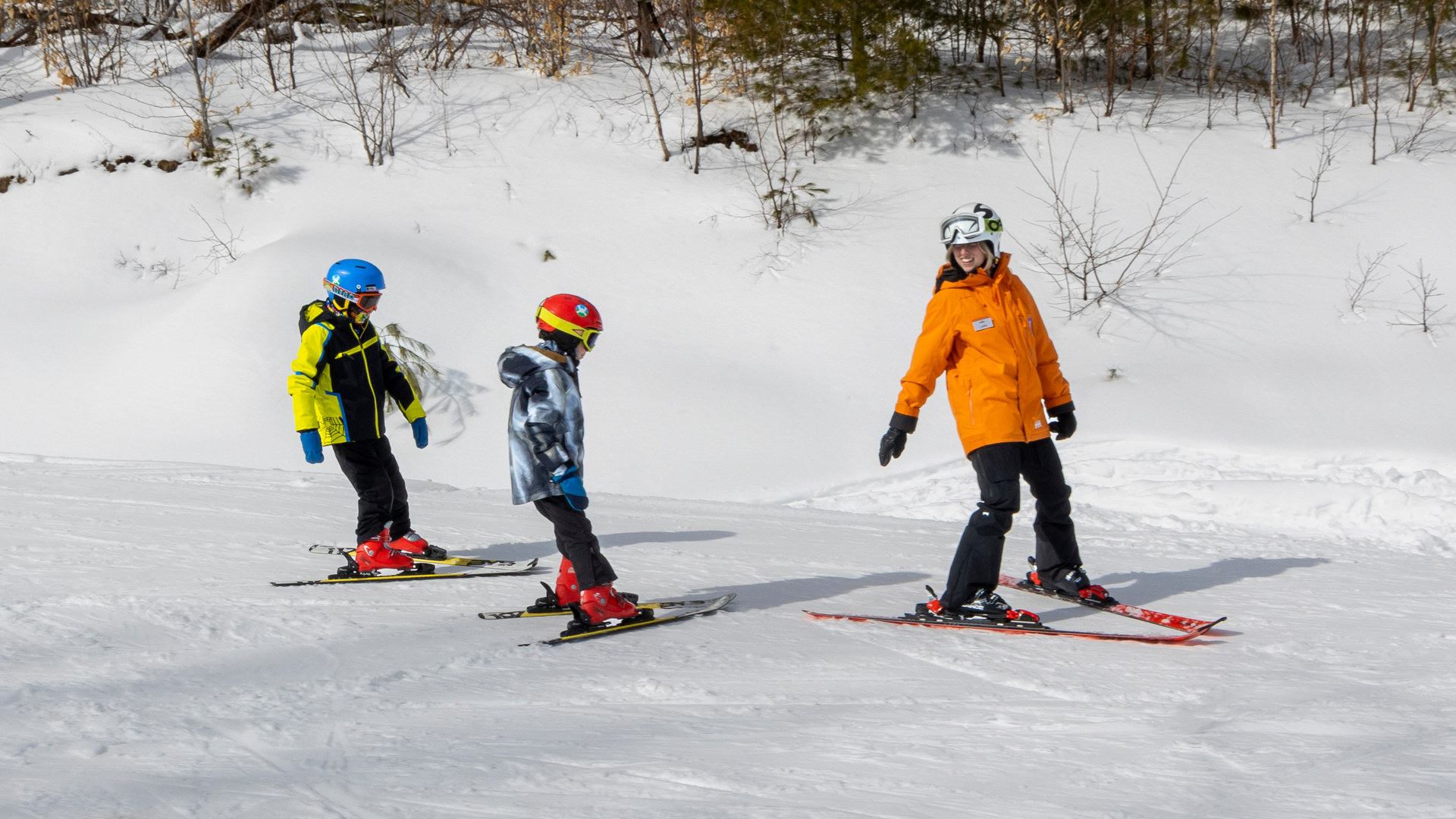 Ski instructor with students on snow