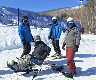 Lakes Regios Disabled Sports staff with a sit skier